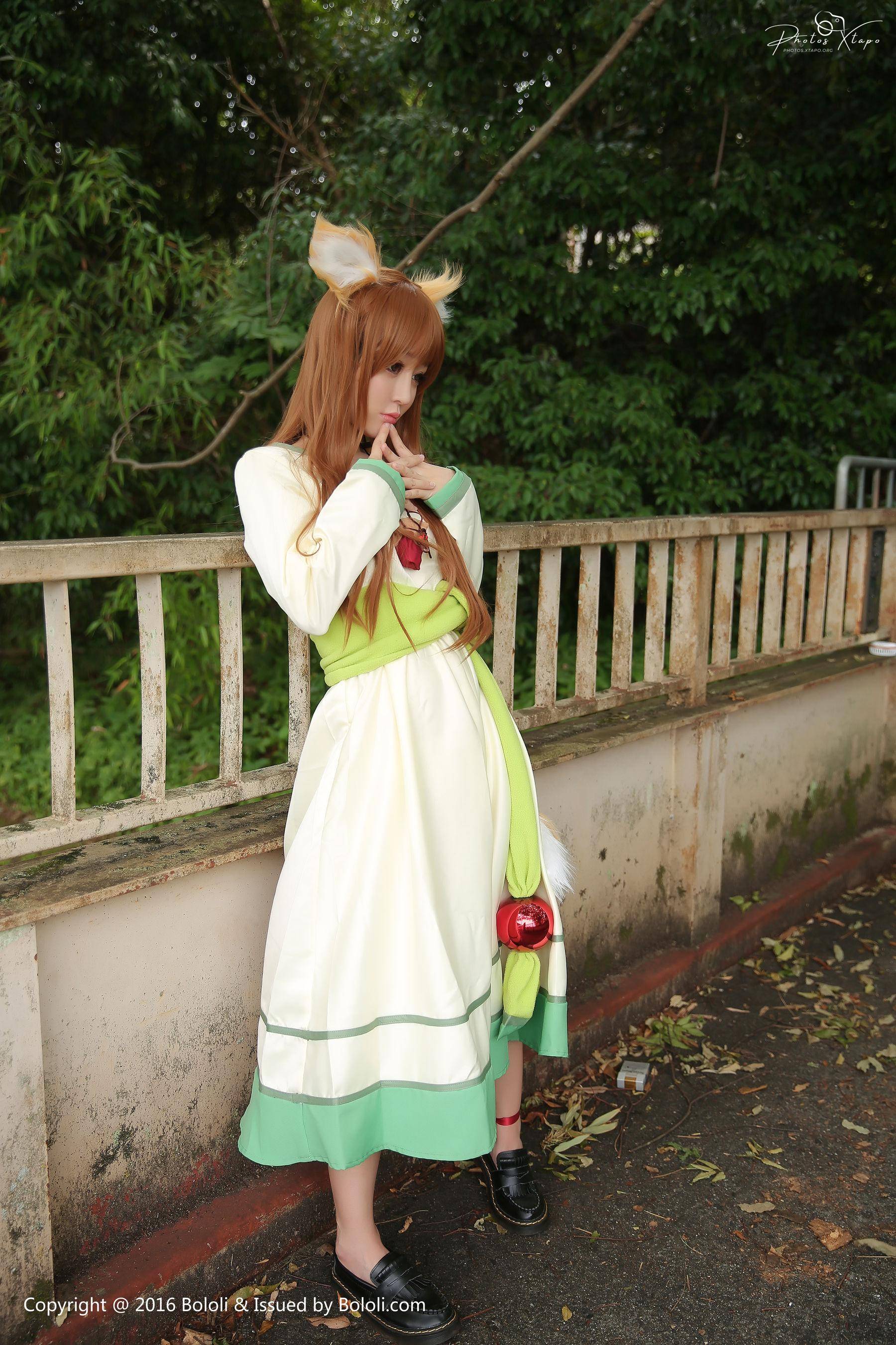 A captivating cosplay of Holo, the wise wolf goddess from Spice and Wolf, captured in a thoughtful pose.  The attention to detail in the costume is remarkable.