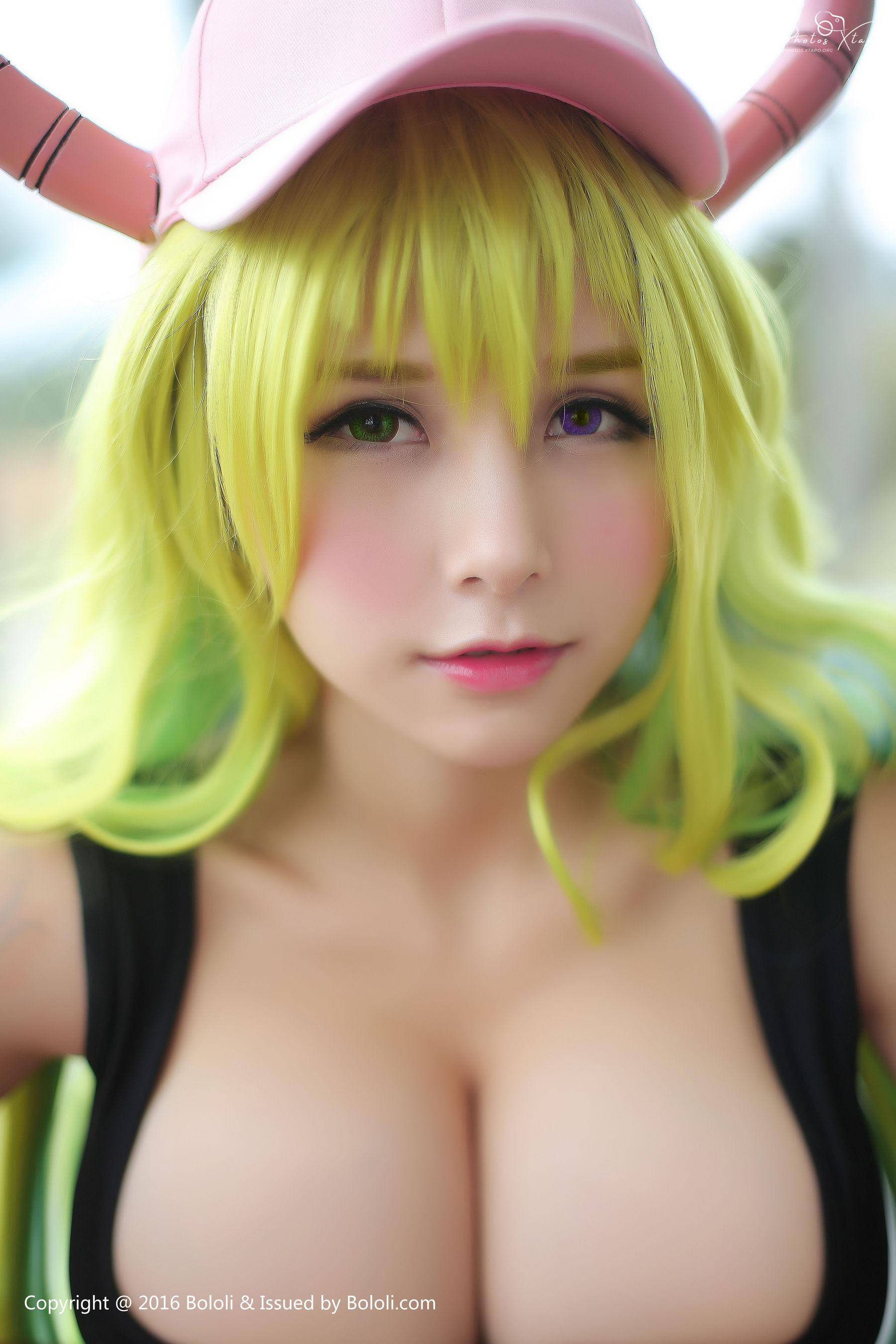A captivating cosplay of Tohru from Miss Kobayashi's Dragon Maid, showcasing vibrant green hair and a charming pink cap.